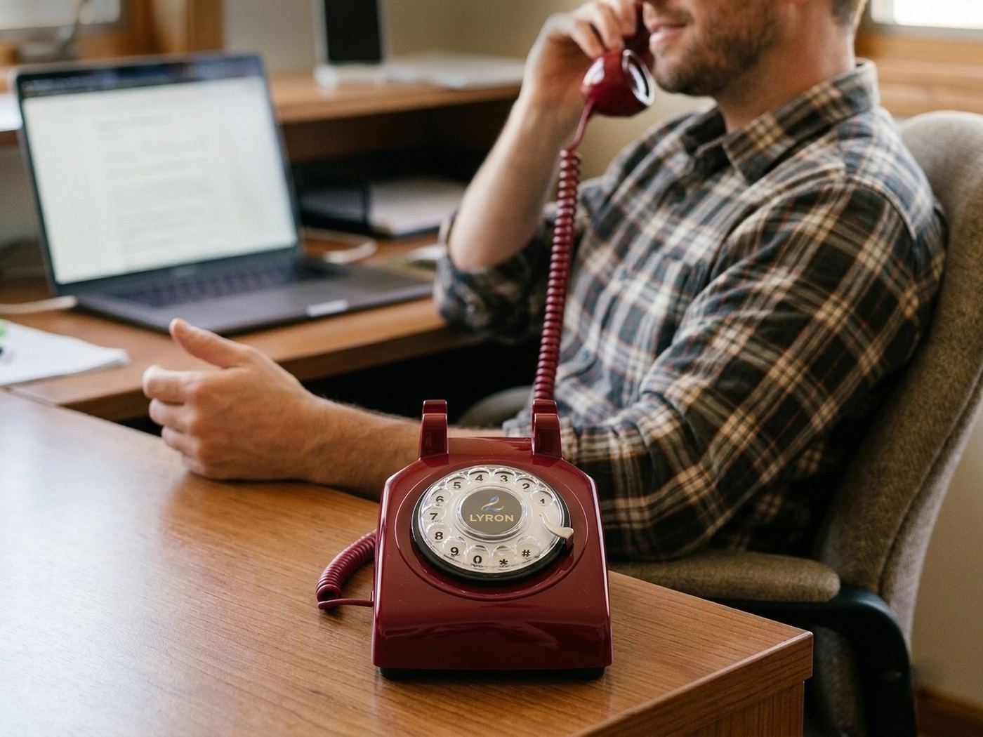 Man taking a call on the LYRON phone at his desk